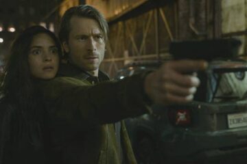 Hit Man 2023 Movie Scene Adria Arjona as Madison Figueroa Masters and Glen Powell as Gary Johnson in an alley holding a gun