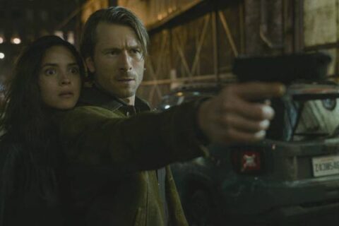 Hit Man 2023 Movie Scene Adria Arjona as Madison Figueroa Masters and Glen Powell as Gary Johnson in an alley holding a gun