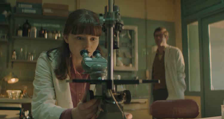 Joy 2024 Movie Scene Thomasin McKenzie as Jean Purdy looking through the microscope during the IVF research