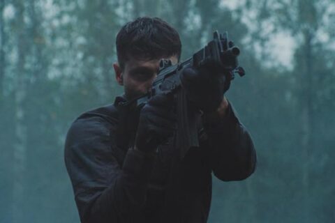 Running With Tigers AKA Tigres Et Hyenes 2024 Movie Scene Waël Sersoub as Malik practicing shooting in the woods before the heist