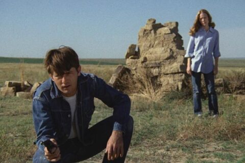 Badlands 1973 Movie Scene Martin Sheen as Kit holding a gun with Sissy Spacek as Holly standing behind him