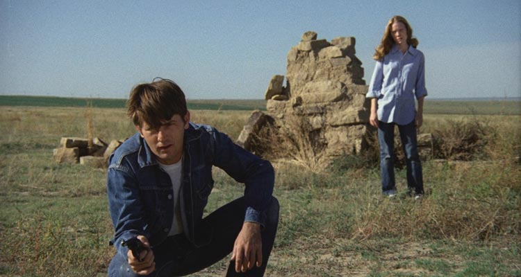 Badlands 1973 Movie Scene Martin Sheen as Kit holding a gun with Sissy Spacek as Holly standing behind him