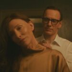 Black Bag 2025 Movie Scene Michael Fassbender as George Woodhouse helping Cate Blanchett as Kathryn St. Jean to put on a dress