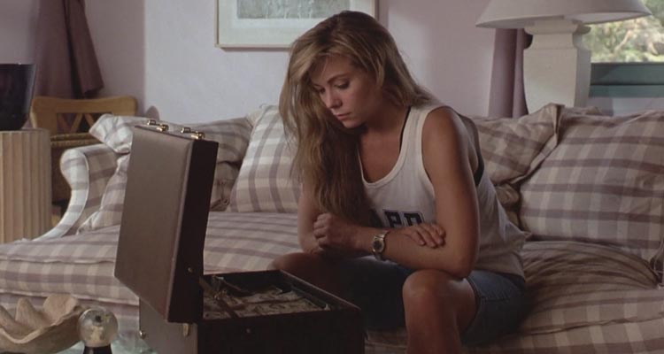 Impulse 1990 Movie Scene Theresa Russell as Lottie Mason in a white shirt looking at a suitcase full of money