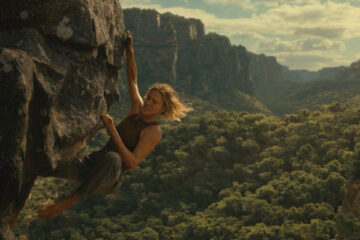 Apex 2026 Movie Scene Charlize Theron as Sasha hanging on the edge of the cliff