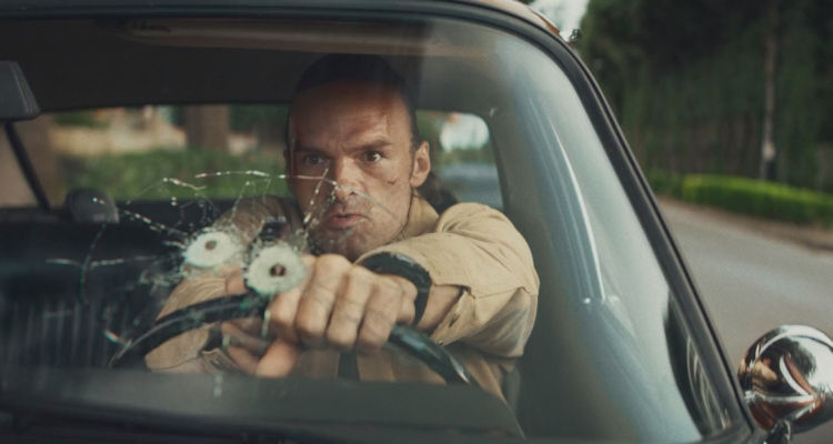The Orphans 2025 Movie Scene Alban Lenoir as Gabriel Stenne Gab shooting through his windshield at the bad guys