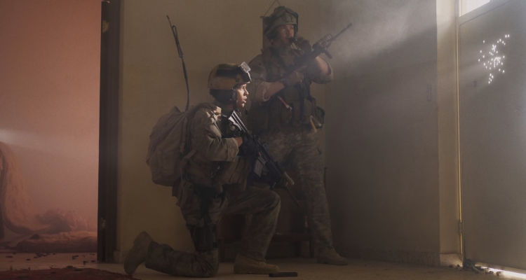 Warfare 2025 Movie Scene D'Pharaoh Woon-A-Tai as Ray and Will Poulter as Erik standing next to the front door calling for backup armed with M4A1 Carbines
